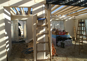 Sonnenspiel mit Balken und Leiter. Blick in die Diele und Wohnzimmer.